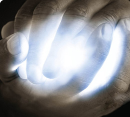 male hands clasped around a bright blue light